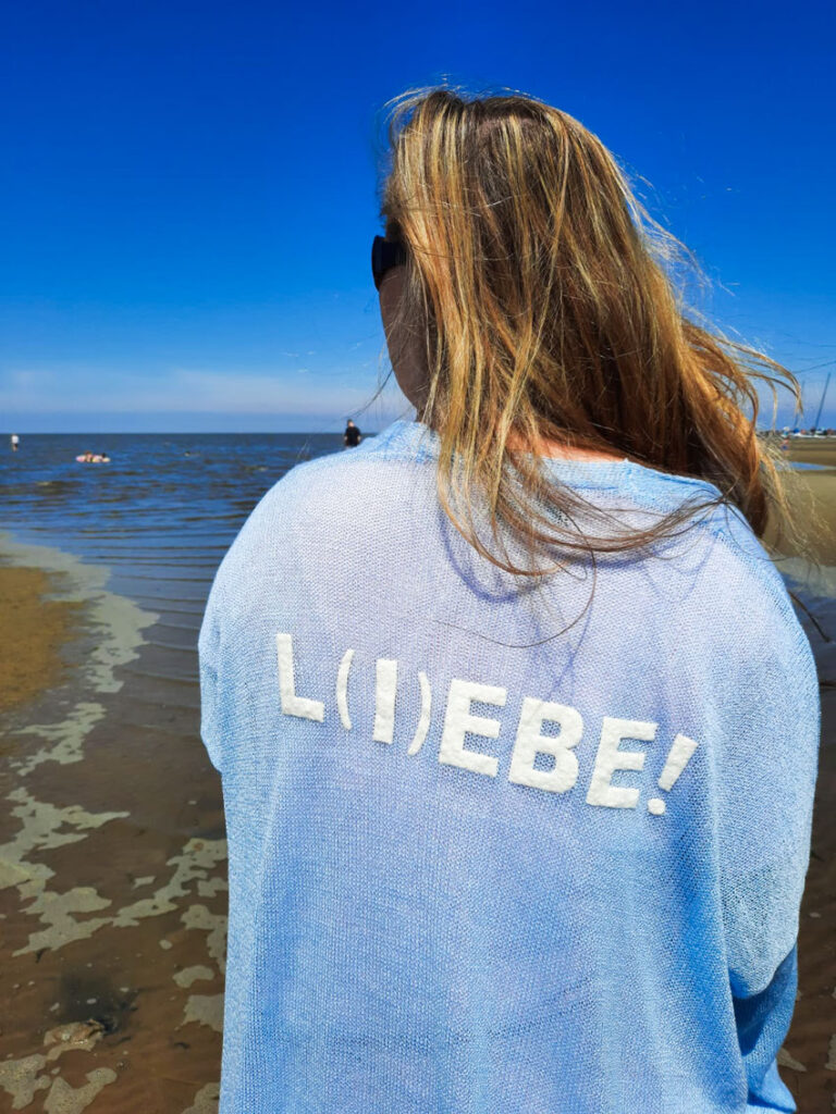 Annika Otten, mit Liebe-Pulloer am Strand
